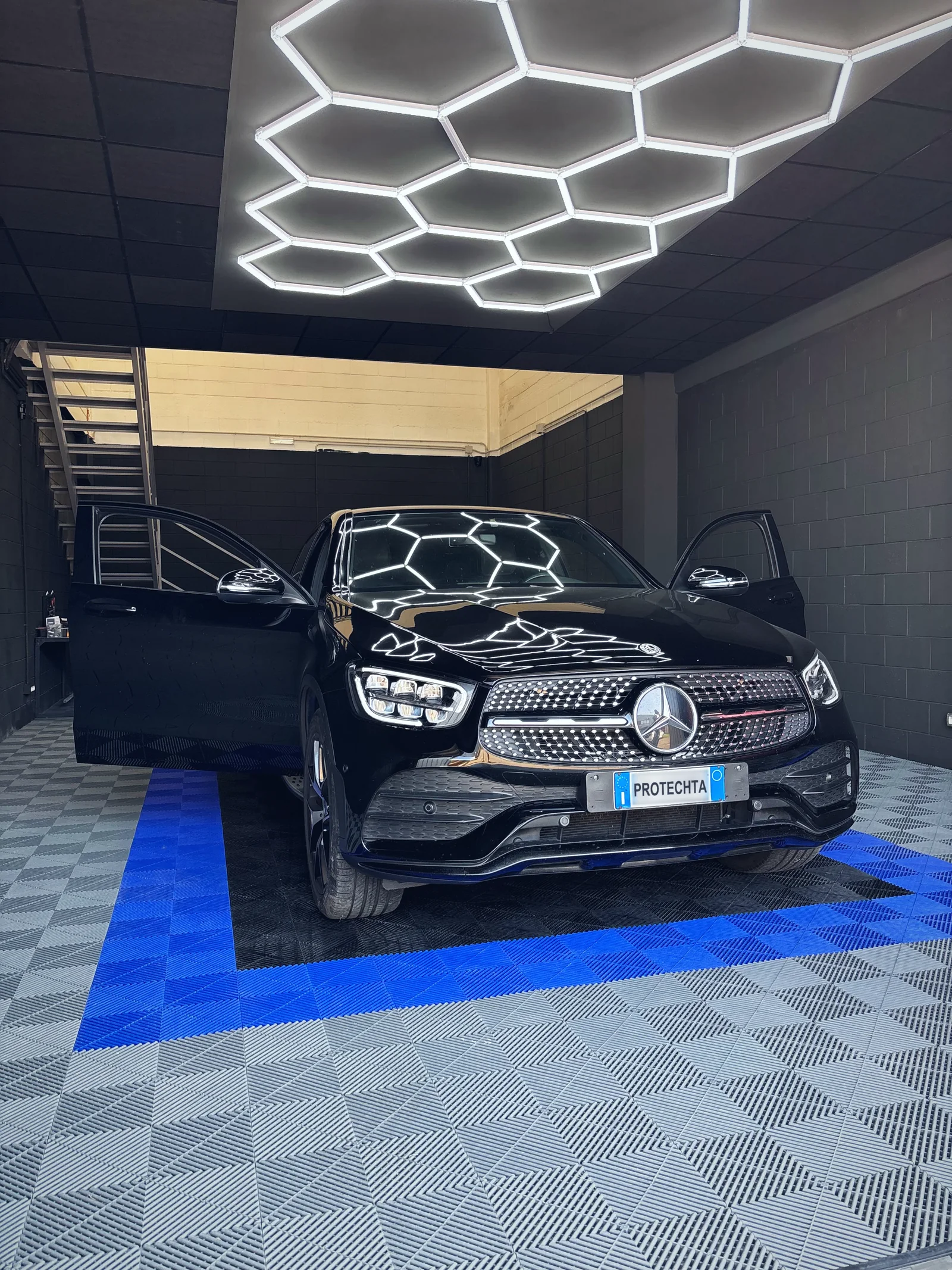 Un'auto in installazione nell'officina Protechta a Settimo Milanese, all'indirizzo indicato nei contatti, sotto la luce a nido d'ape